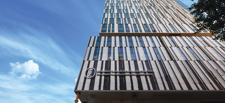A tall skyscraper against a blue sky. Lettering on the building reads The David H. Koch Center for Cancer Care. 