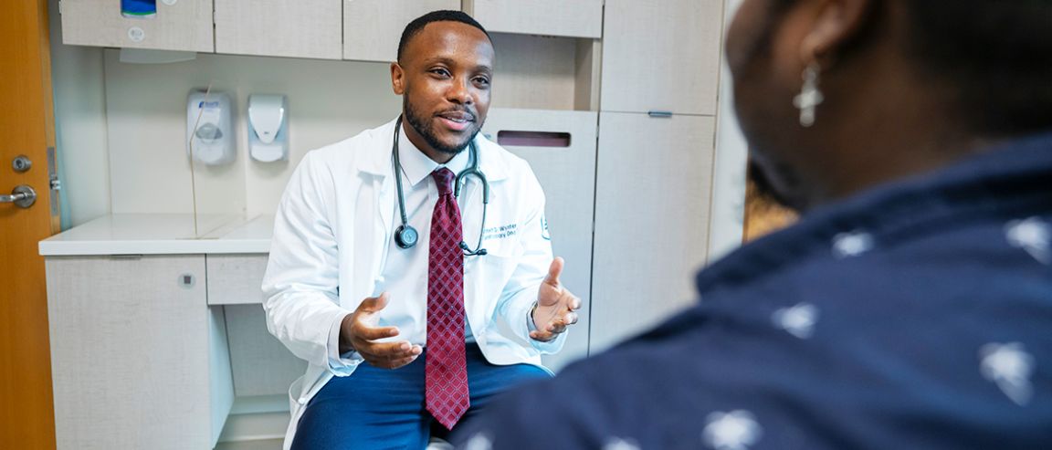 An MSK doctor speaks to a patient in a treatment room. 